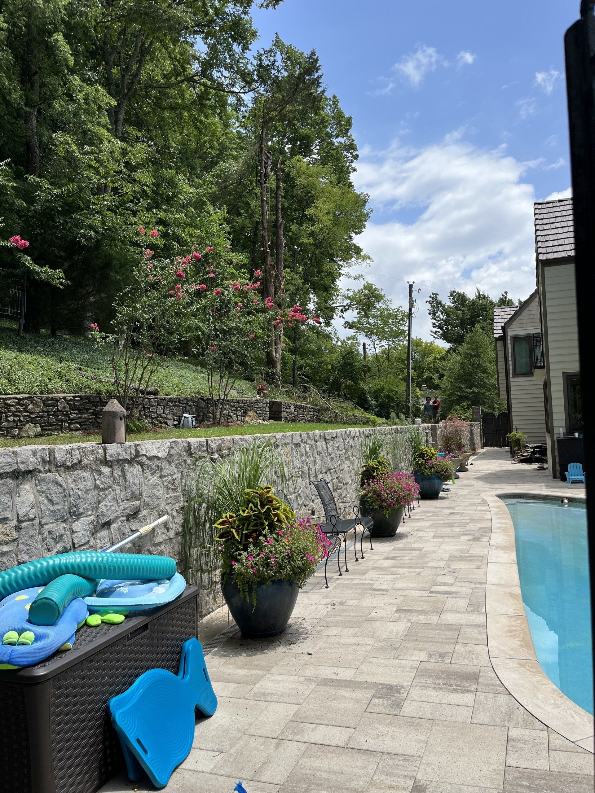A patio with a swimming pool and a house in the background