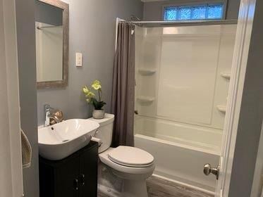 A bathroom with a toilet , sink , and bathtub.