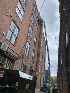 A large brick building with a crane on the side of it.