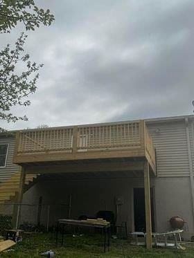 A wooden deck is being built on the back of a house.