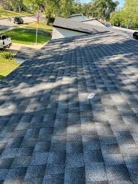 The roof of a house with a gray shingle roof.