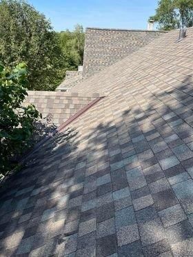 A roof with a lot of tiles on it and trees in the background.