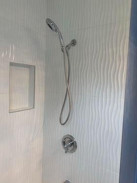 A shower with a shower head and a bathtub.