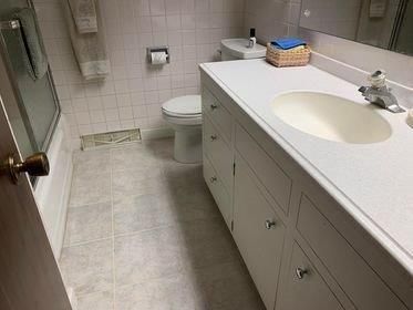 A bathroom with a toilet , sink , and mirror.