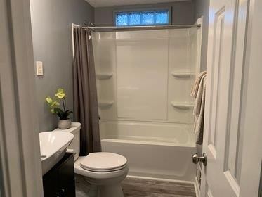 A bathroom with a toilet , sink , tub and shower.