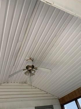 A ceiling fan is hanging from the ceiling of a room.