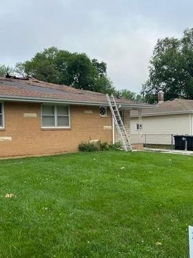 A brick house with a ladder attached to the side of it.