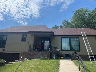 A house with a red roof and a ladder in front of it.
