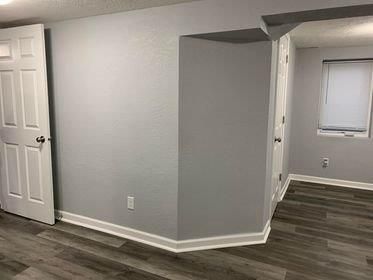 A corner of a room with a door and a window.