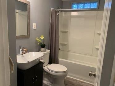 A bathroom with a toilet , sink , and bathtub.