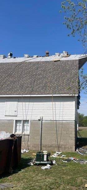 A white house with a gray roof is being remodeled.