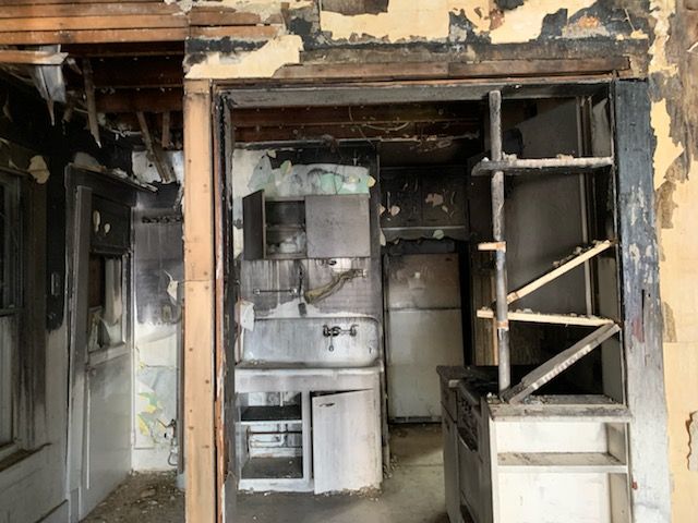 An old kitchen with a refrigerator , sink , and stove.