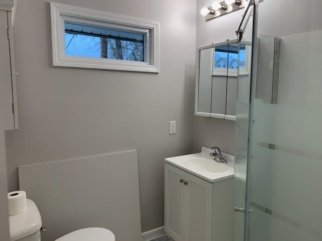 A bathroom with a toilet , sink , and shower.