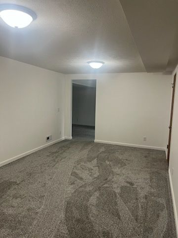 A large empty room with a carpeted floor and white walls.