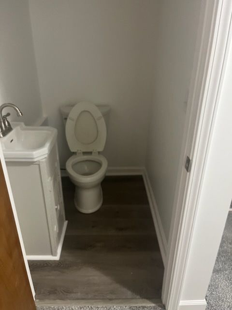 A bathroom with a toilet , sink and vanity.