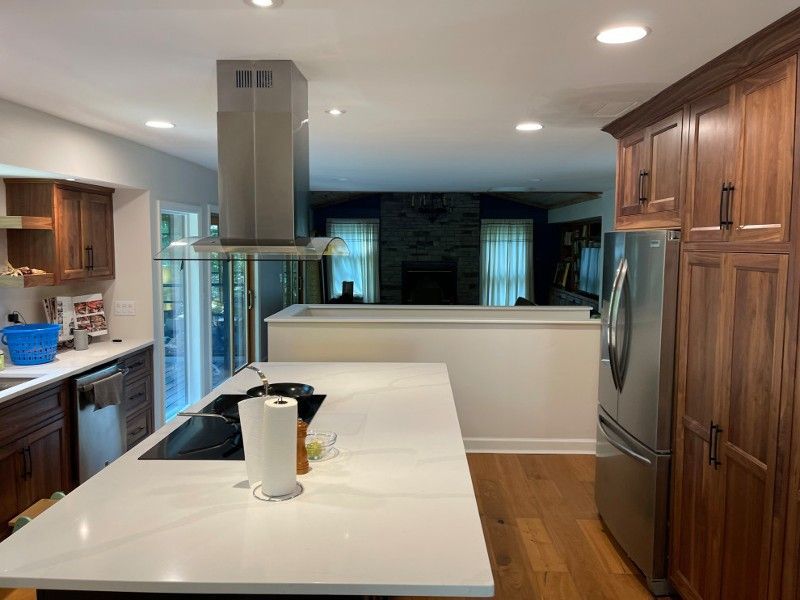 A kitchen with a large island and a stove top oven.