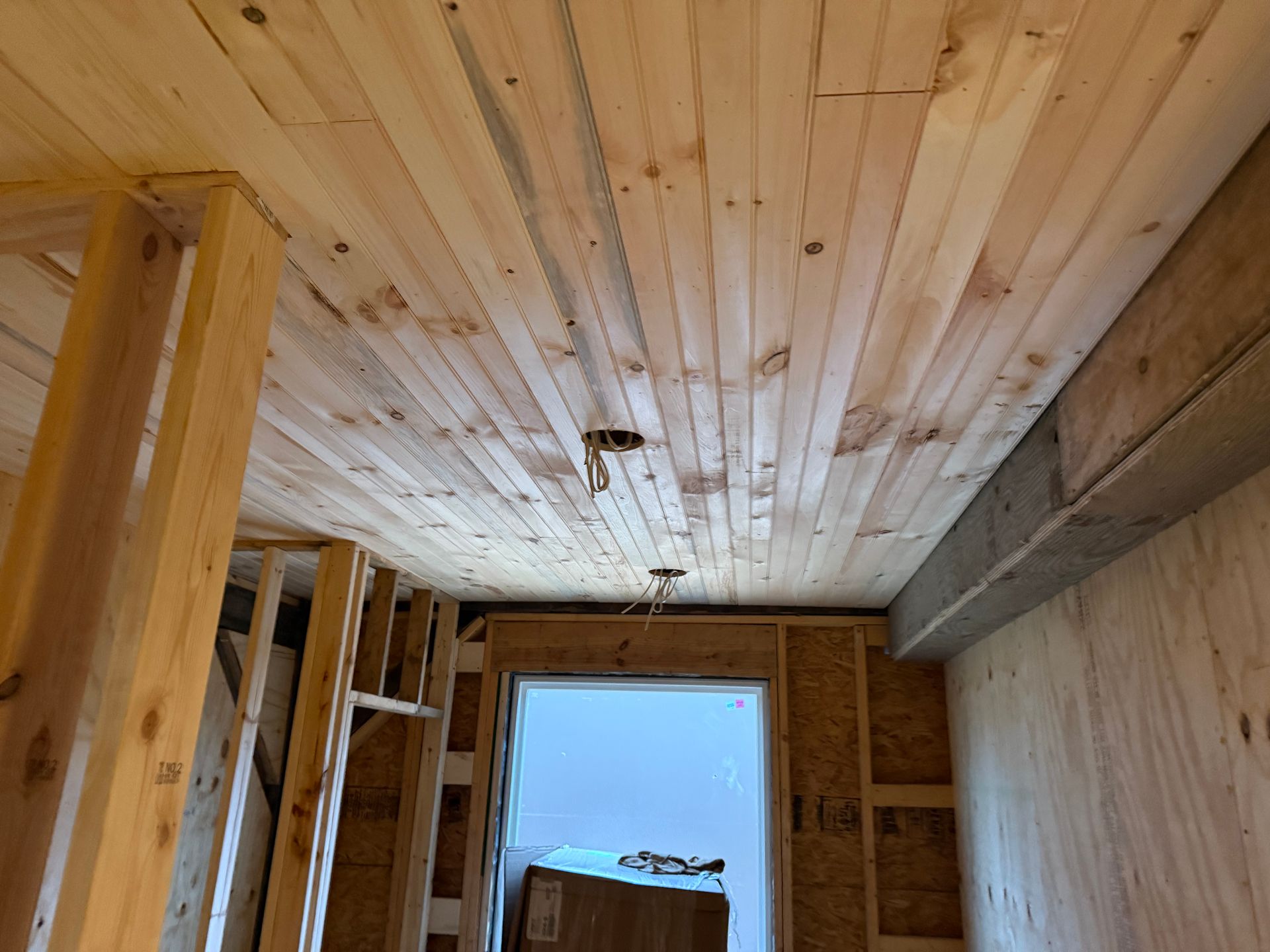 A room with a wooden ceiling and a door