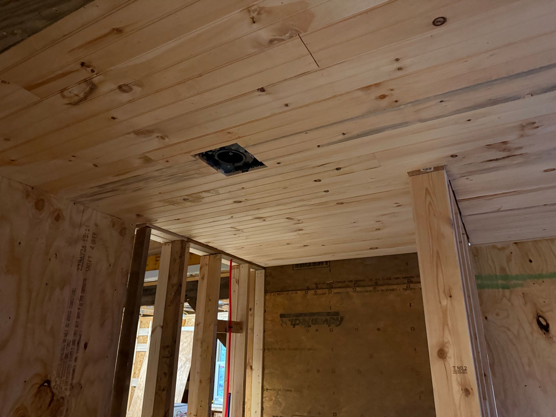 A wooden ceiling with a hole in it in a room under construction.