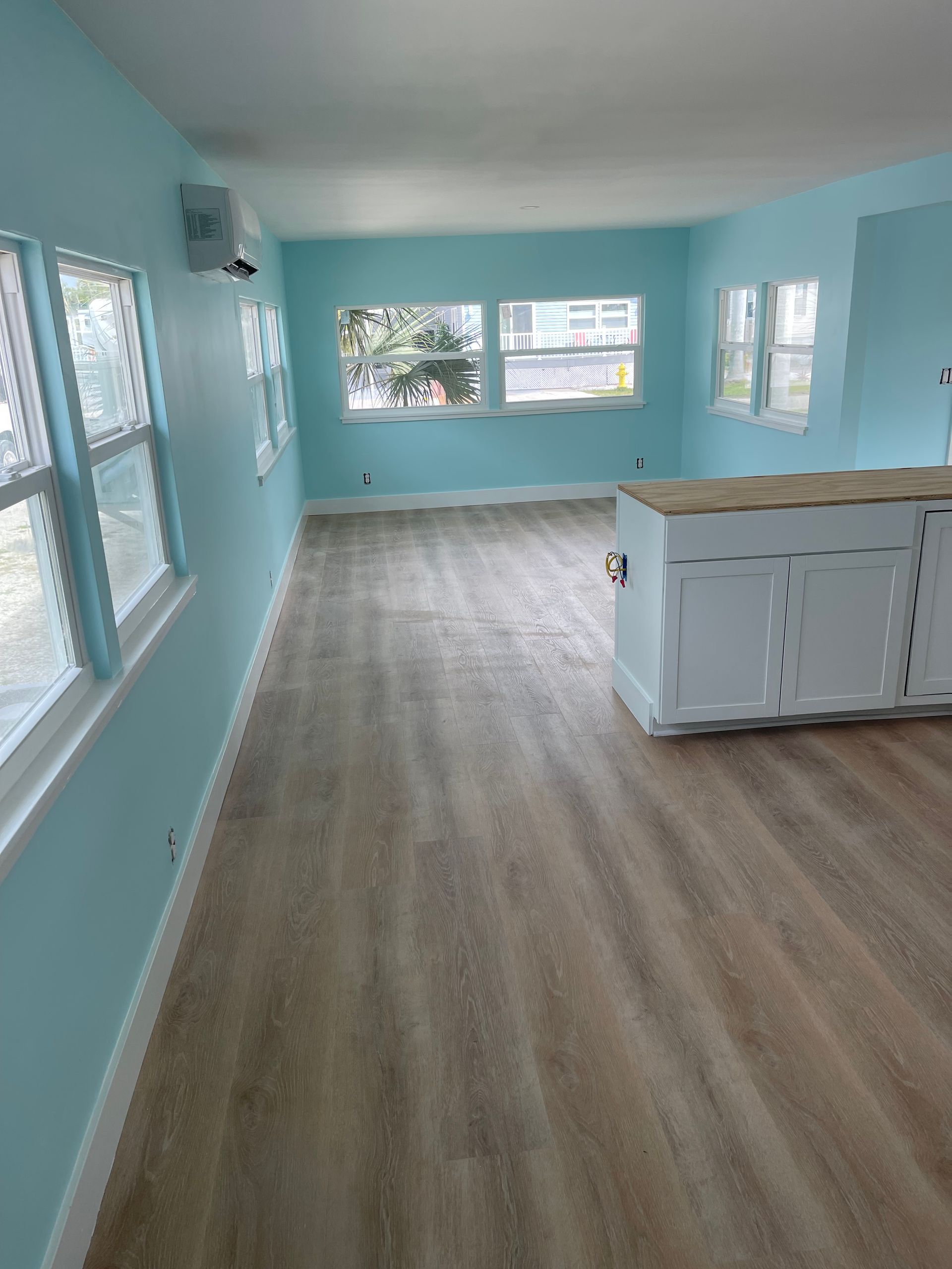 An empty living room with hardwood floors and blue walls.