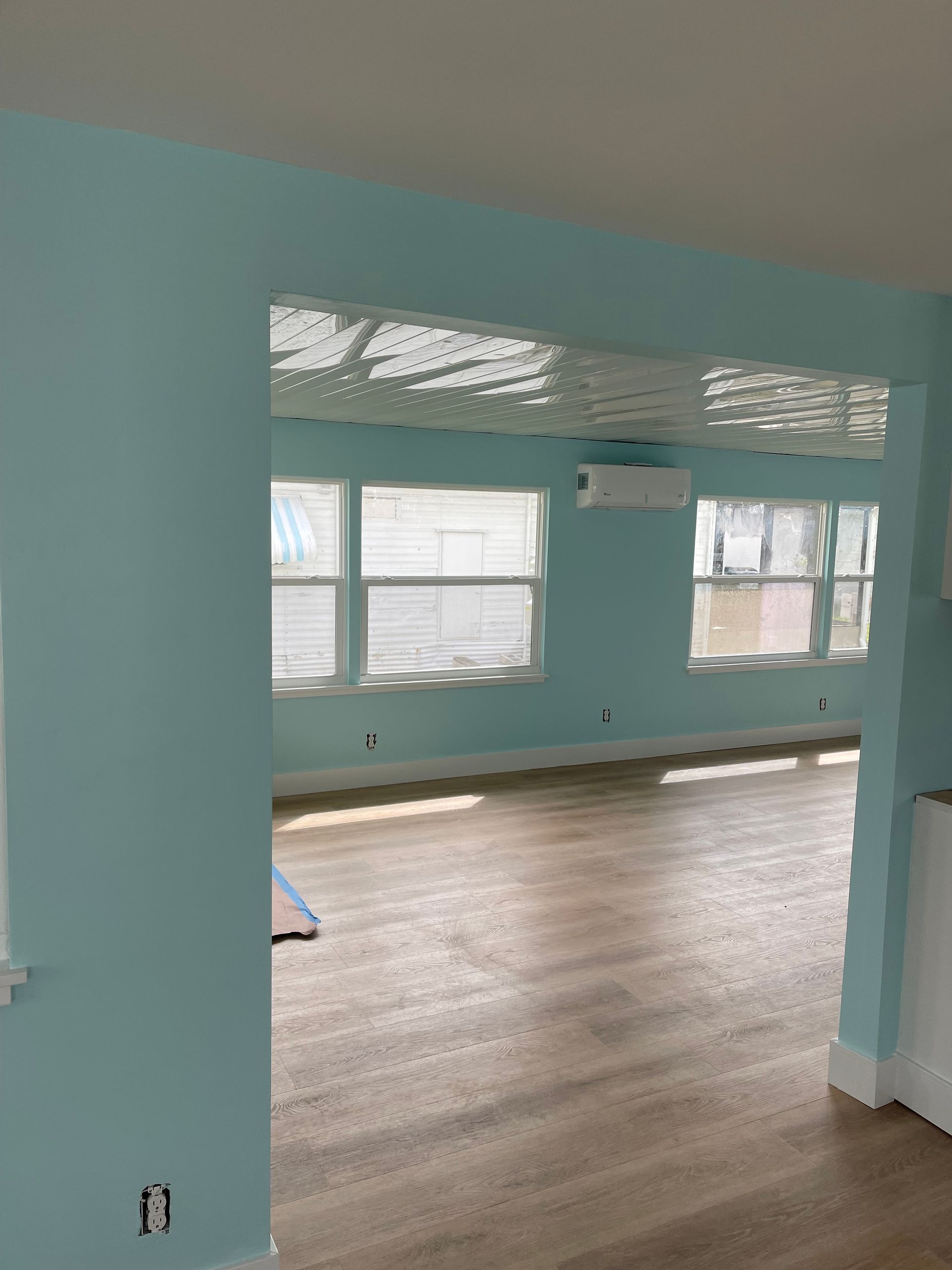 A living room with blue walls and hardwood floors.