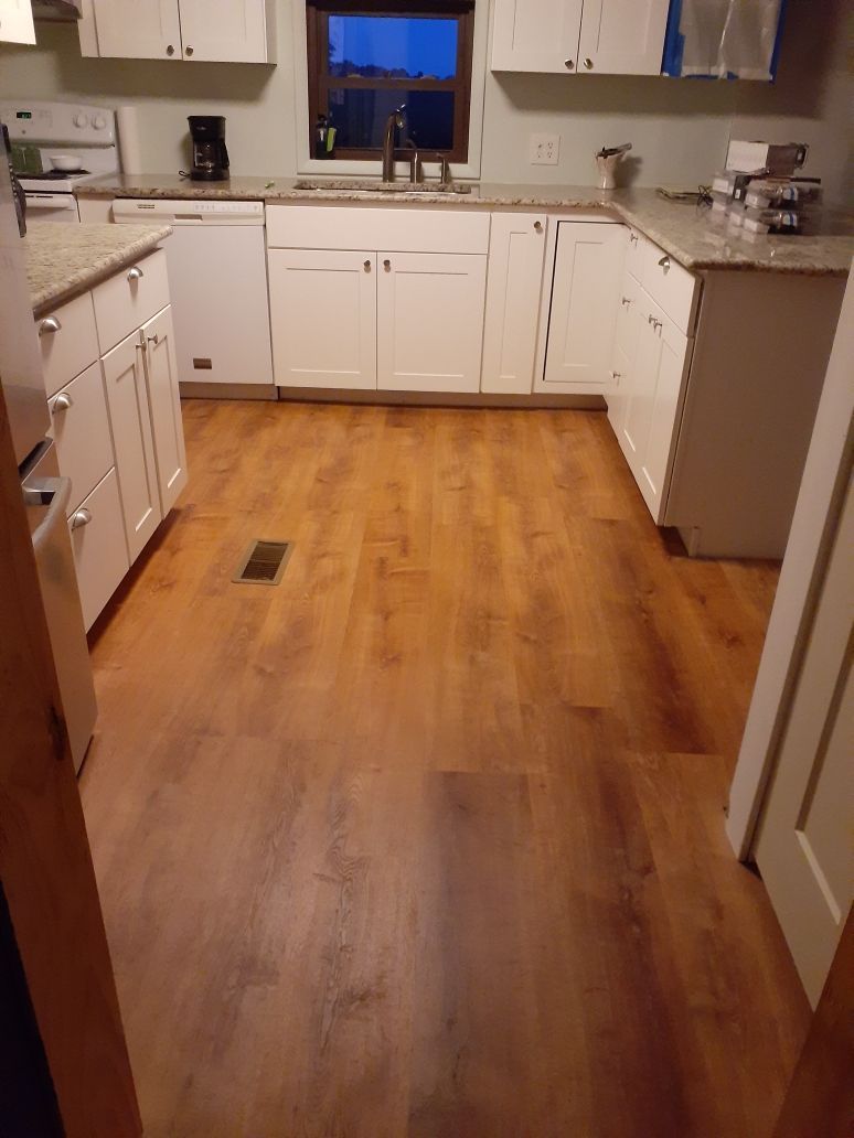 A kitchen with hardwood floors and white cabinets.
