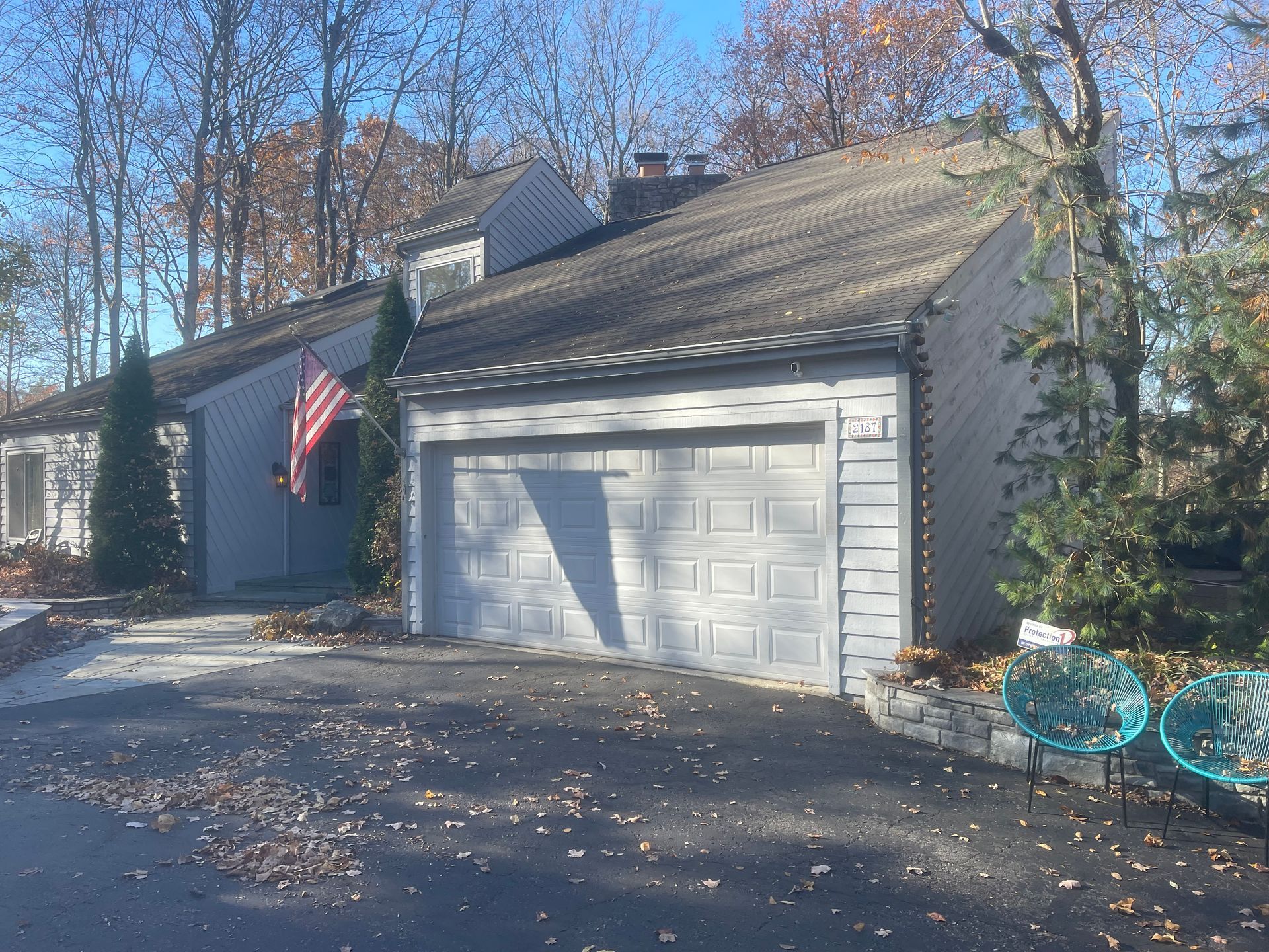 A house with a garage and an american flag on the front