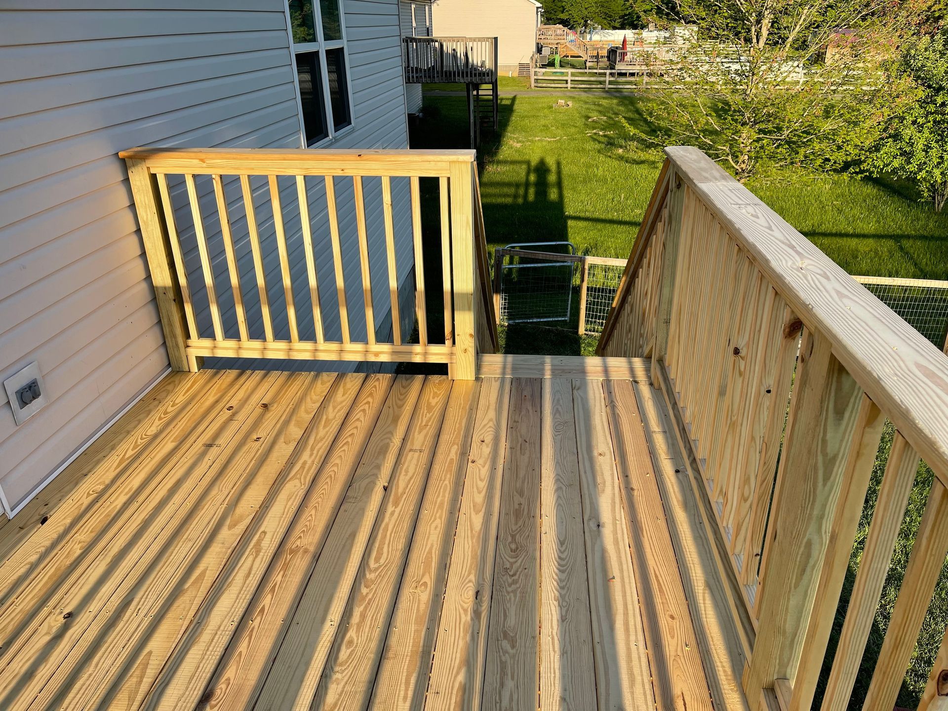 A wooden deck with a railing and stairs leading up to it
