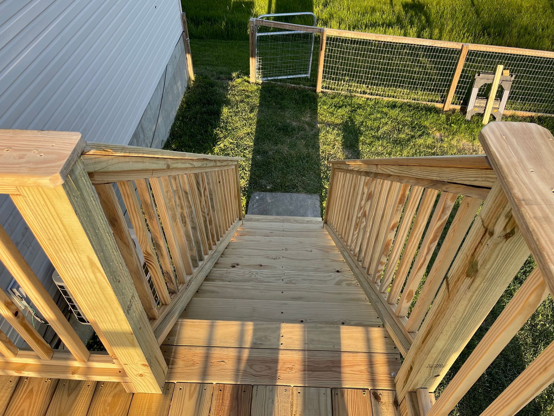 A wooden deck with stairs leading up to a house.