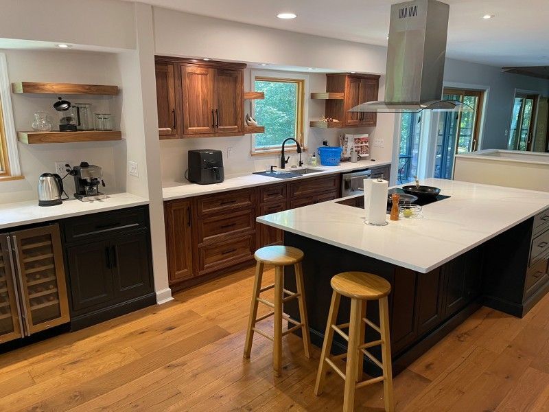 A kitchen with stools and a large island in the middle.