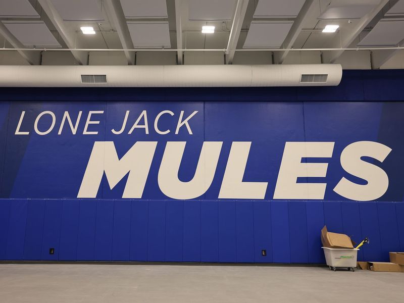 A blue wall inside a gymnasium with the words 