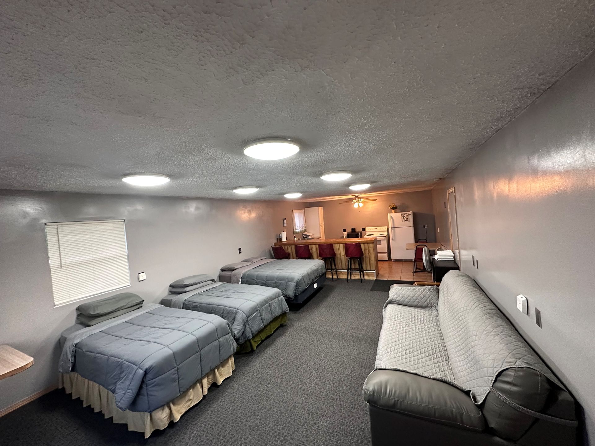 A room with four beds and a couch in it