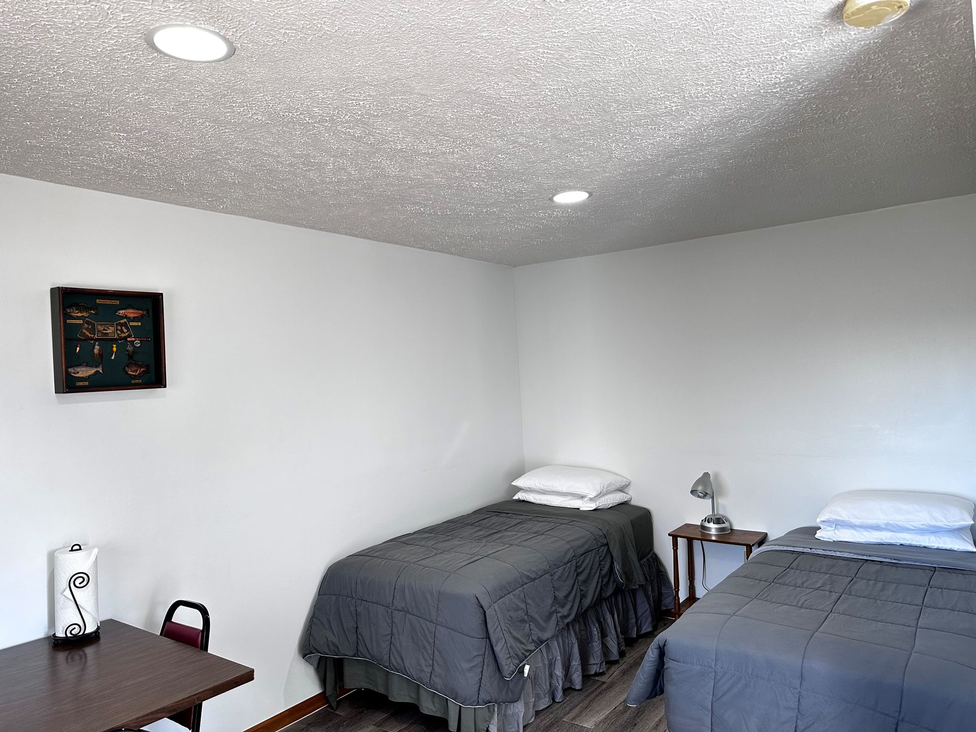 A bedroom with two beds and a desk.