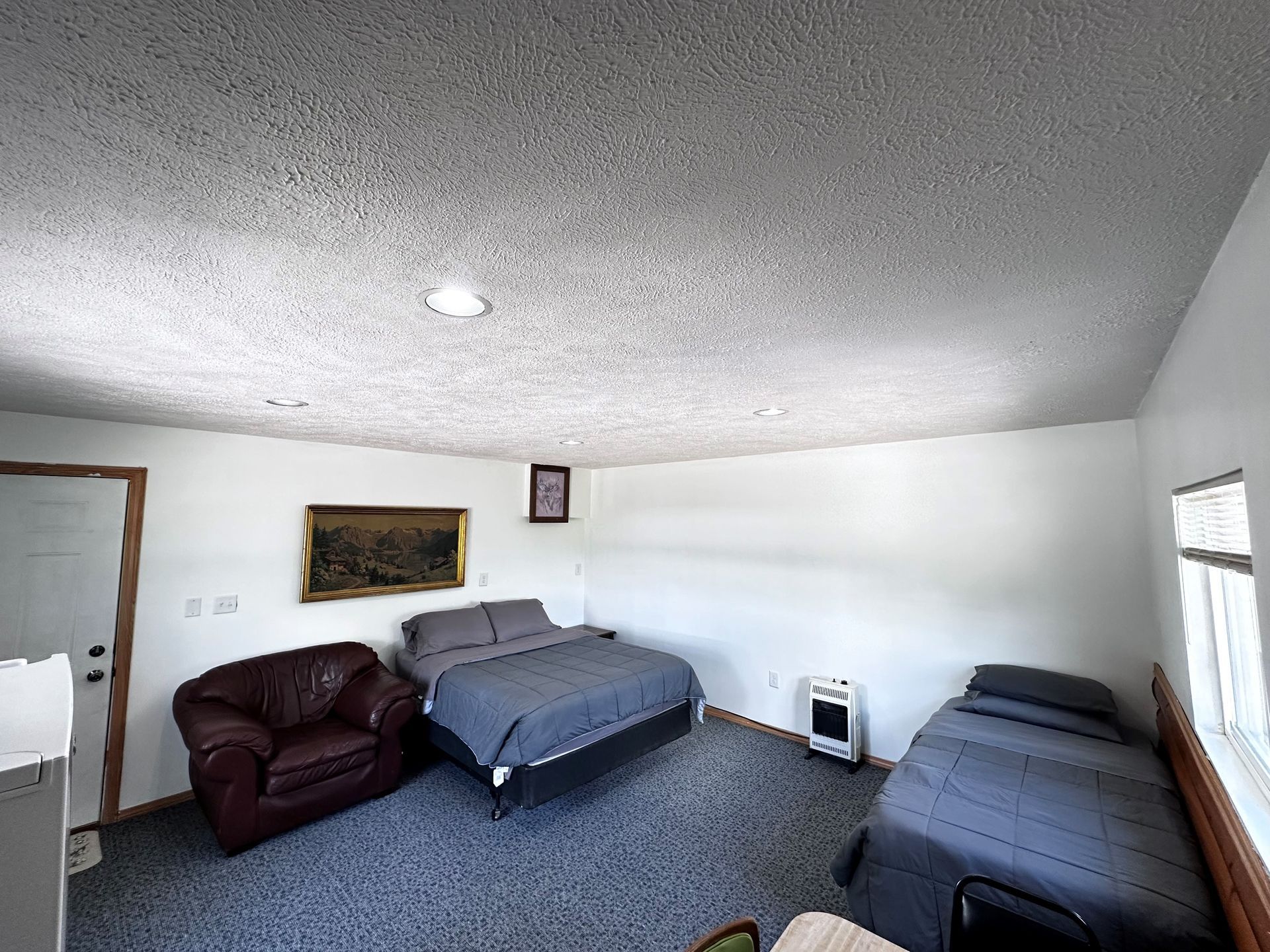 A bedroom with two beds and a chair in it