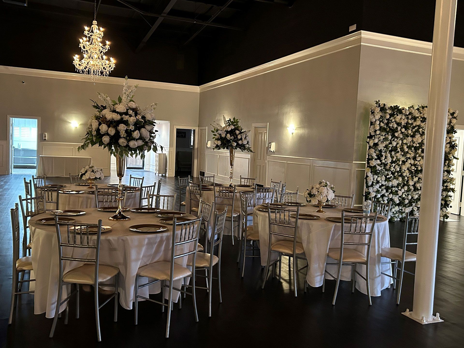 A large room with tables and chairs set up for a wedding reception