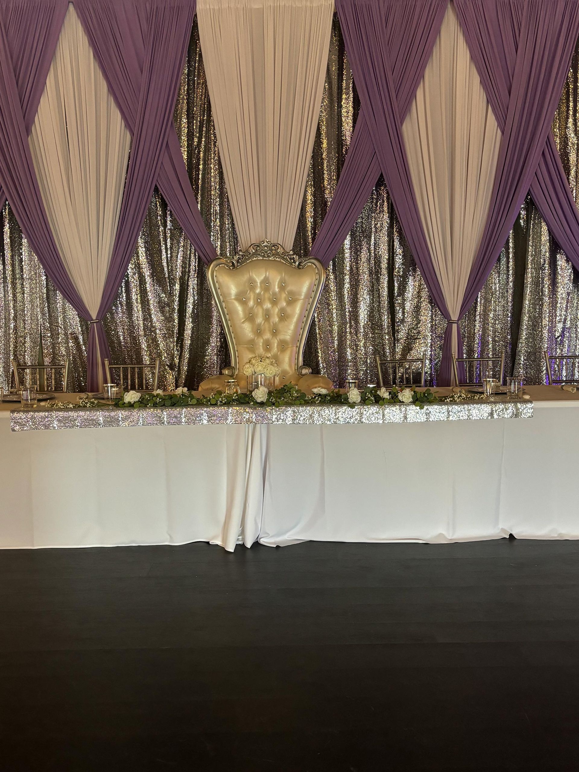 Chair in front of a wall with white and purple curtains