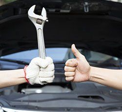 Mechanic holding a wrench and a thumbs up