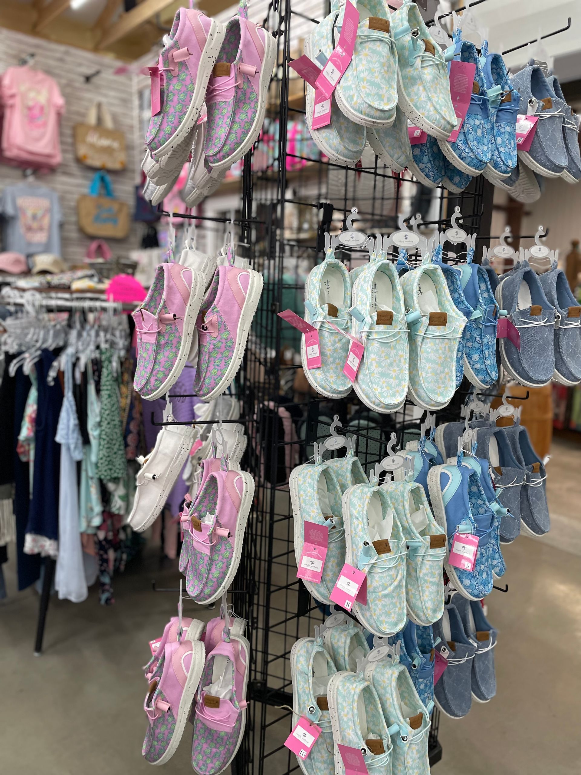 A bunch of shoes are hanging on a rack in a store.