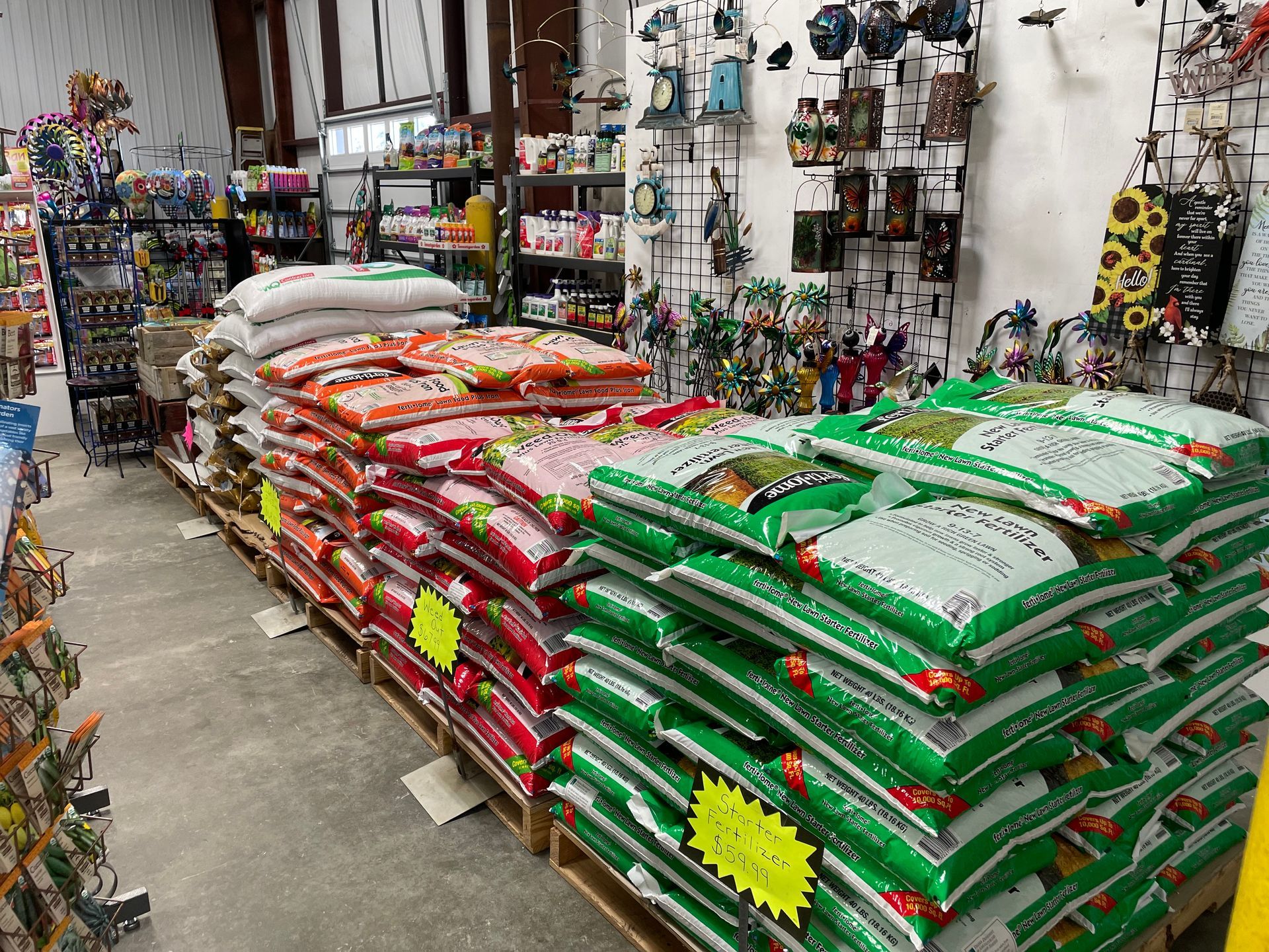 A store aisle stacked with bags of pet food in green, red, and white packaging