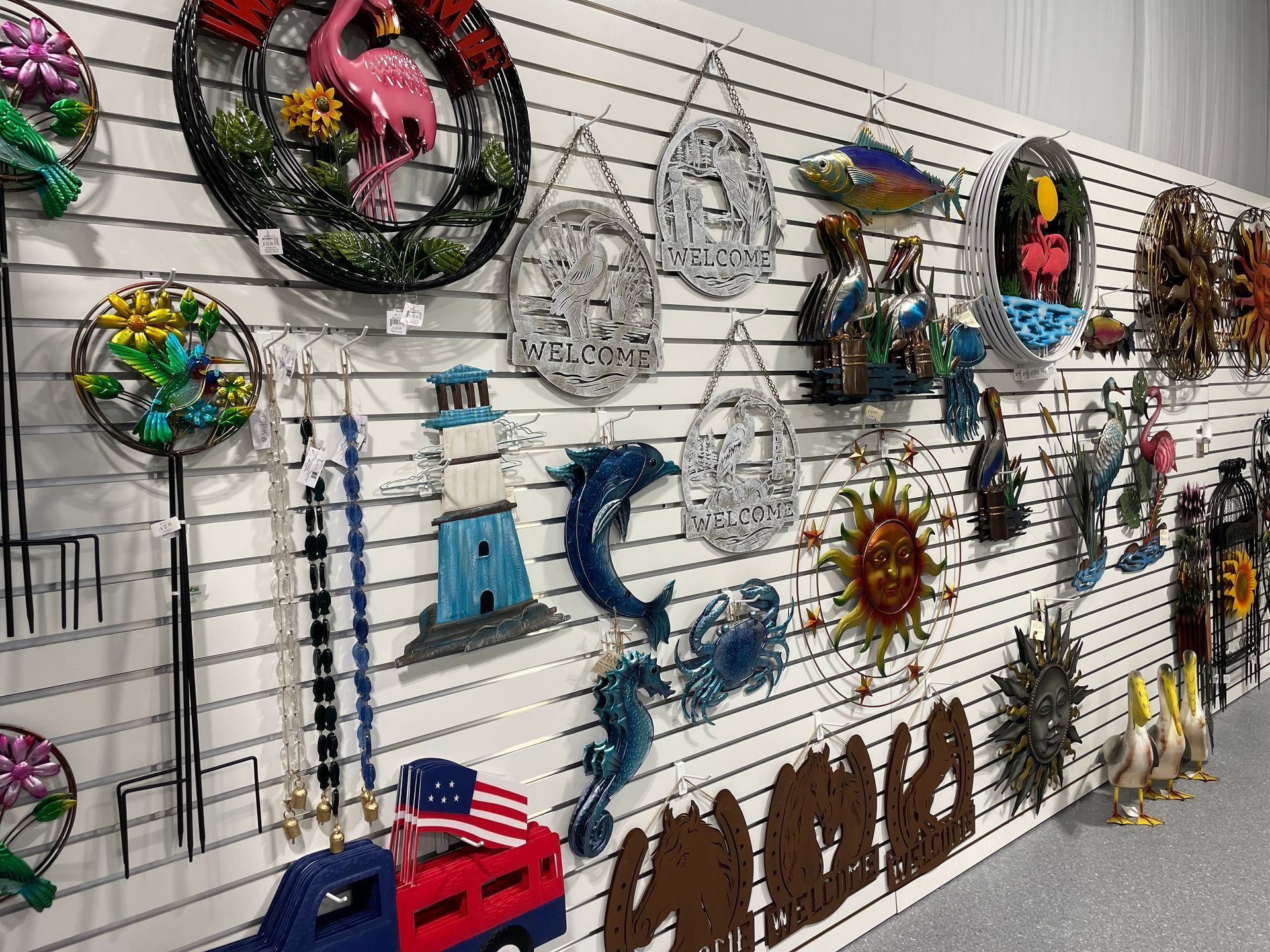 Colorful wire art and wall hangings displayed on a slatted gallery wall