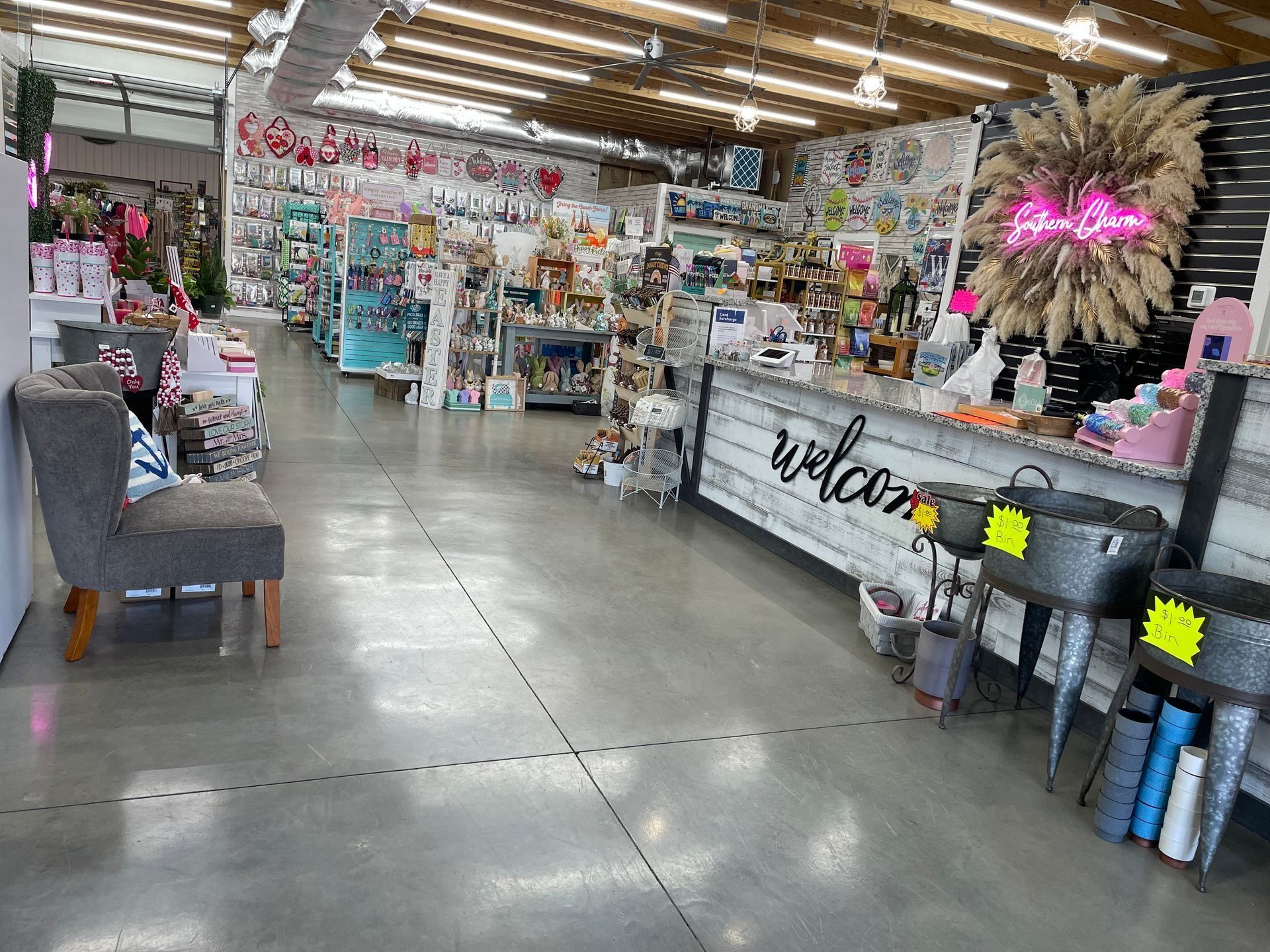 Gift shop aisle with colorful decor, shelves of merchandise, and a gray chair under bright overhead lights