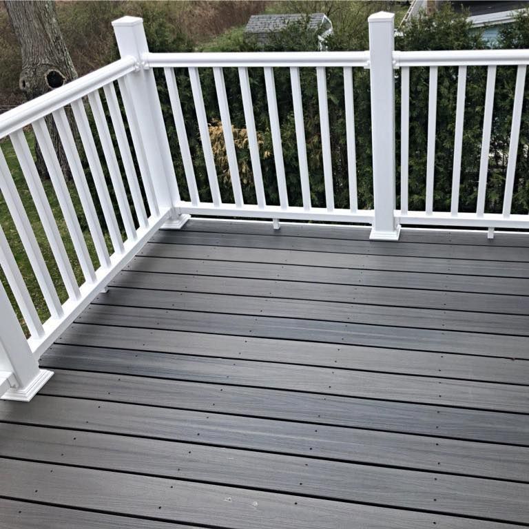 Gray composite deck with white railing, outdoors.