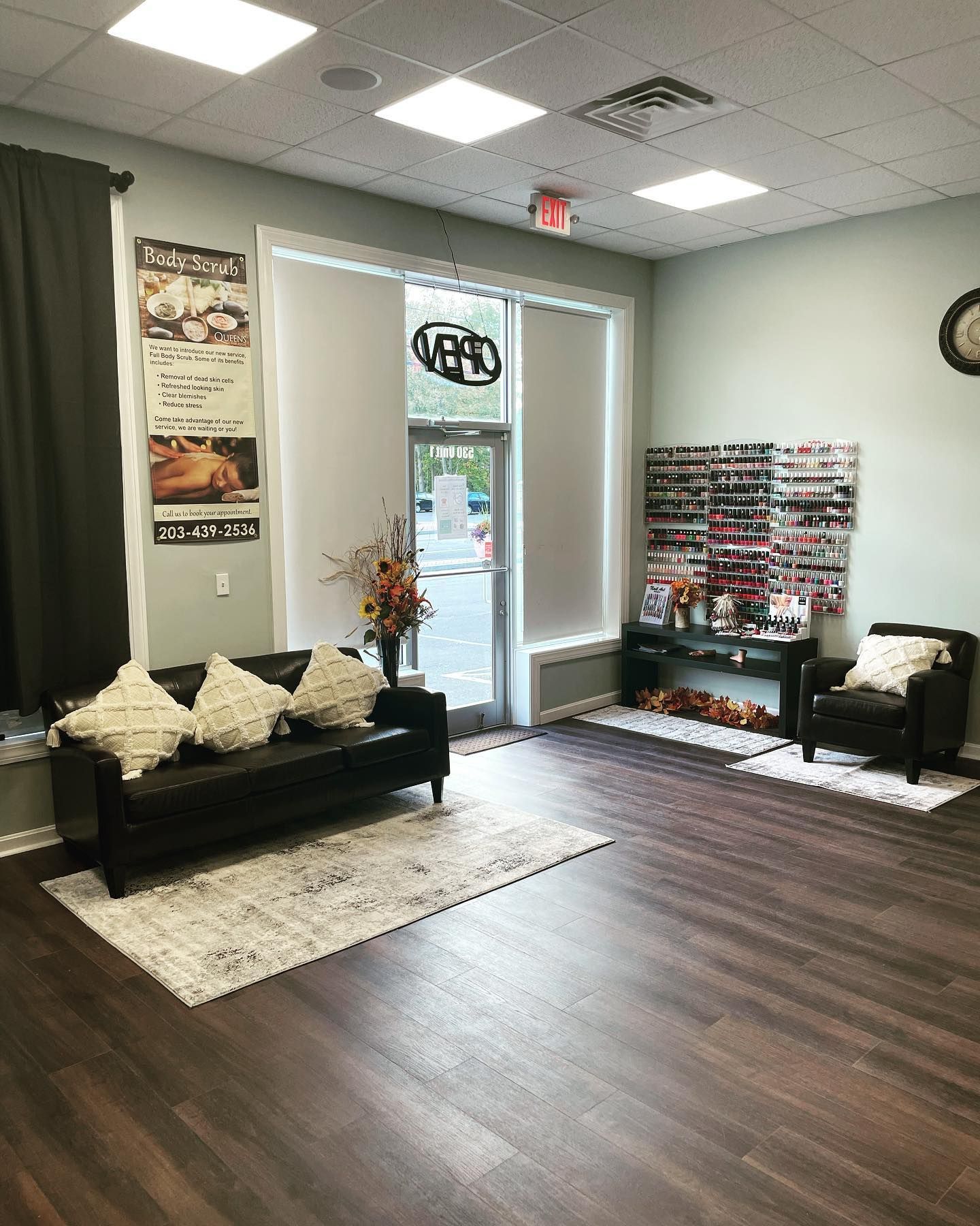 Nail salon interior with seating, nail polish display, and open door.