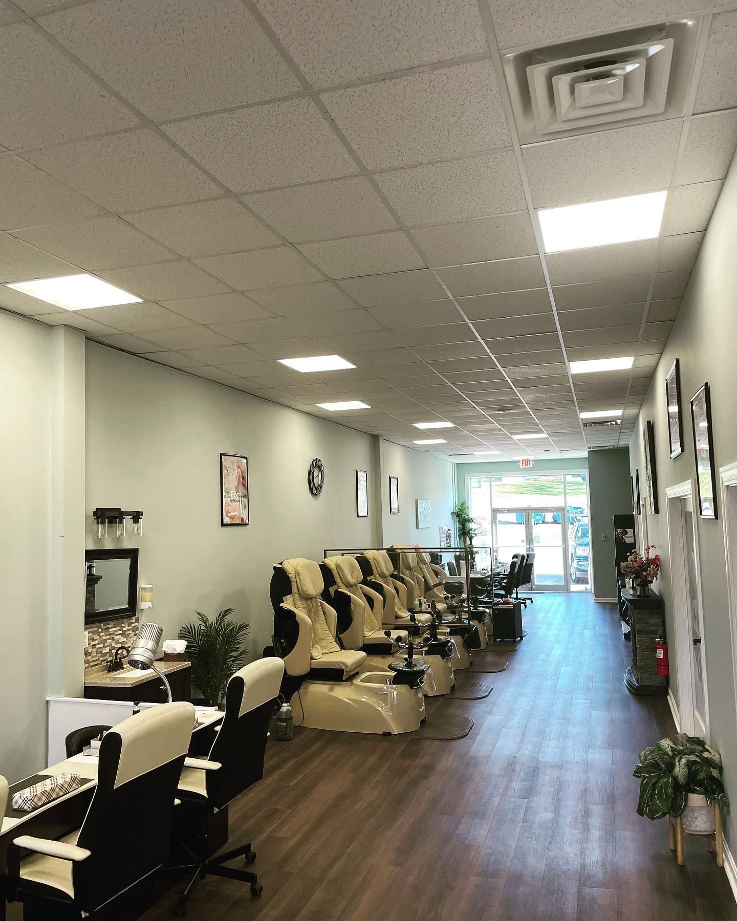 Interior of a nail salon with rows of pedicure chairs and manicure stations.