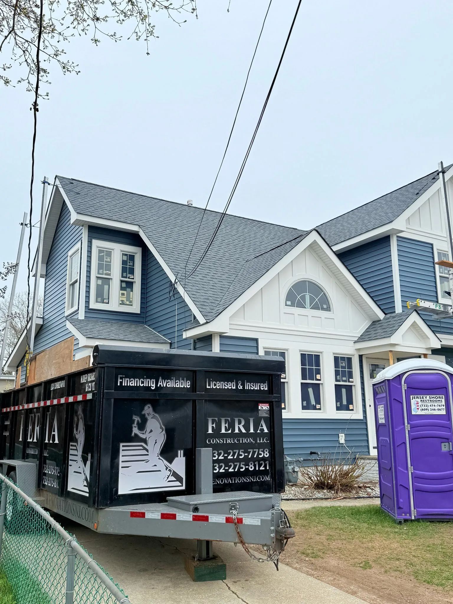 Food truck parked beside a blue house with a purple portable toilet in front