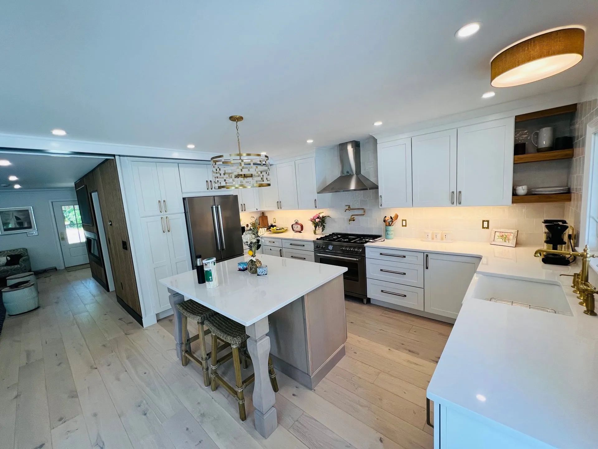 Bright modern kitchen with white cabinets, central island, and stainless steel appliances