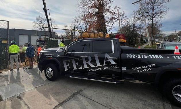 Black TERRA tow truck at a roadside scene with workers and traffic cones, utility pole down nearby