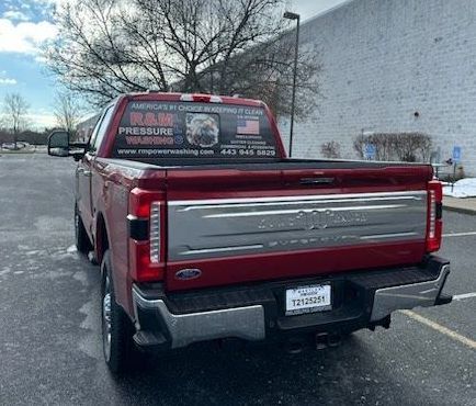 A red ford truck is parked in a parking lot.