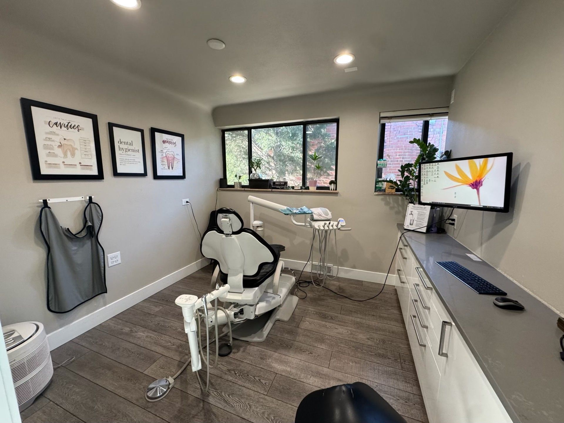 A dental office with a dental chair and a computer.