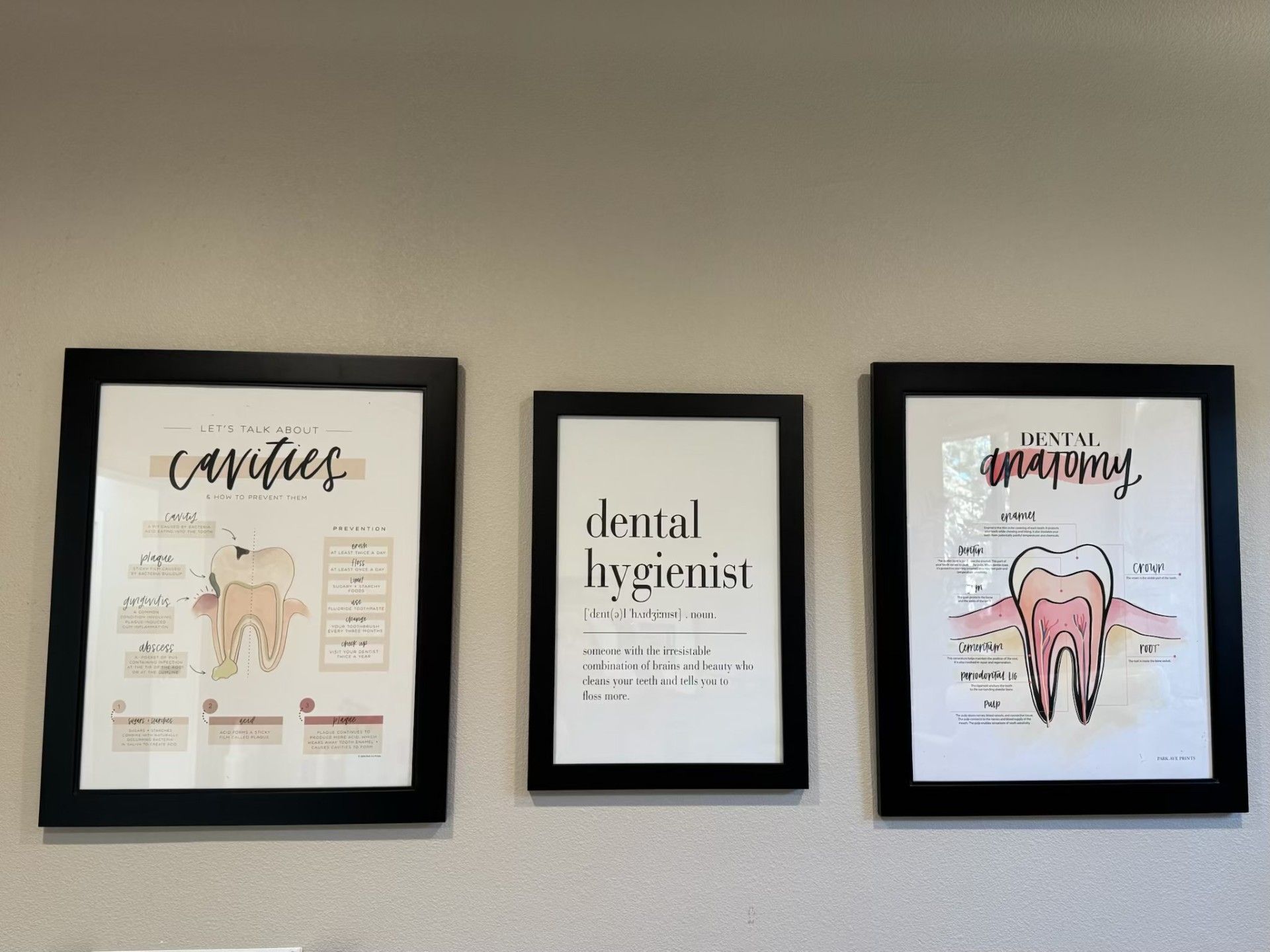 Three framed pictures on a wall one of which says dental hygienist