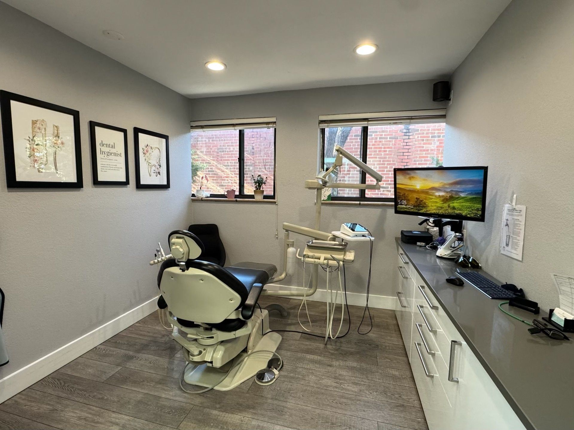 A dental office with a dental chair and a computer.
